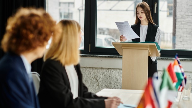 Junge Dame an einem Rednerpult während einer Besprechung