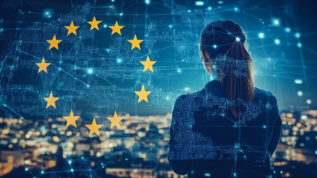 Rückansicht einer Frau, die auf eine Stadt bei Nacht blickt, überlagert von digitalen Netzwerken und der Flagge der Europäischen Union 