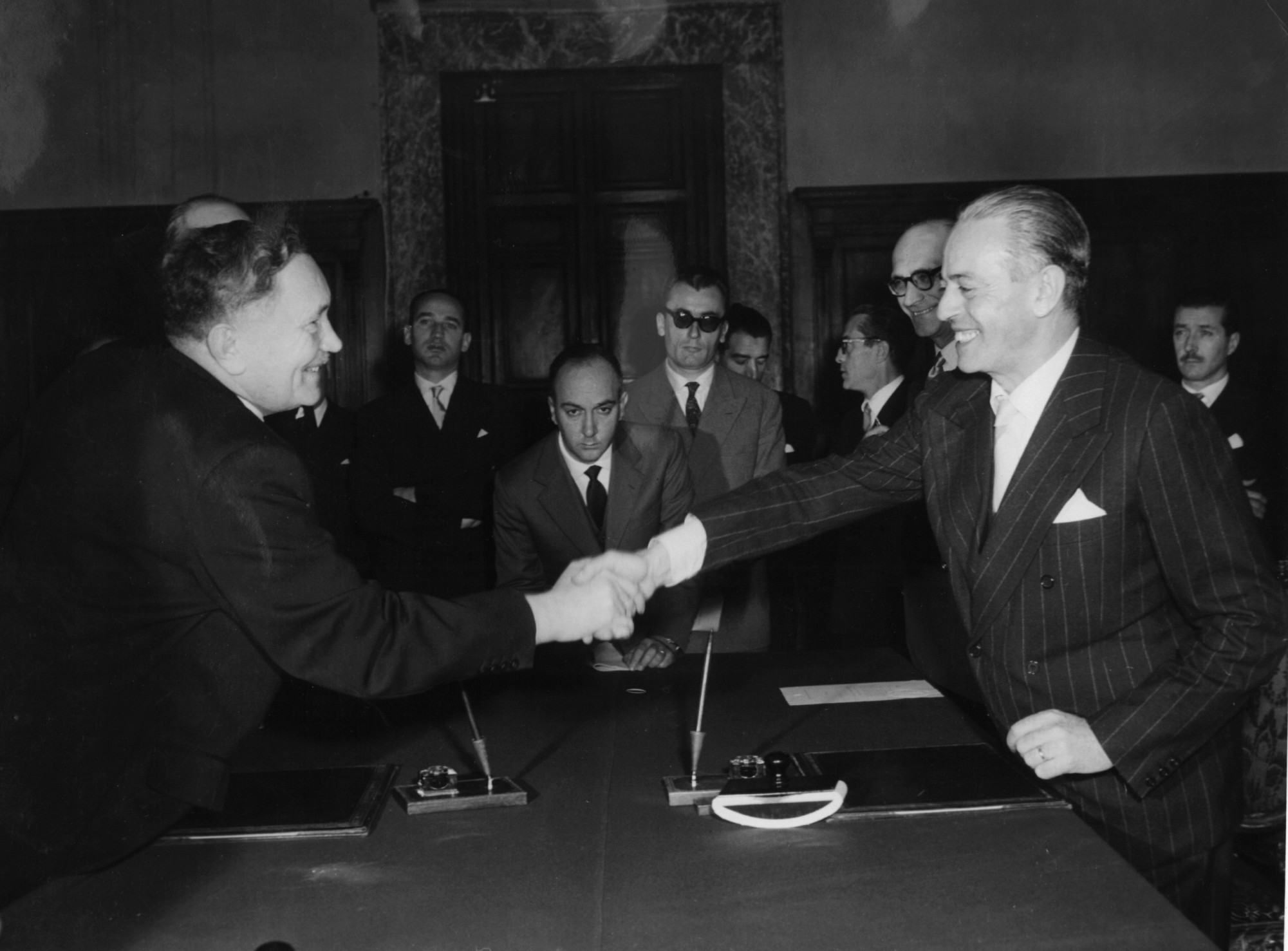 Bild des Handschlags zwischen Bundesarbeitsminister Anton Storch, links zu sehen und des italienischen Außenministers Gaetano Martino, rechts zu sehen